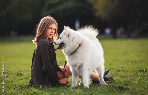 Pretty girl and samoyed dog on grass © leszekglasner