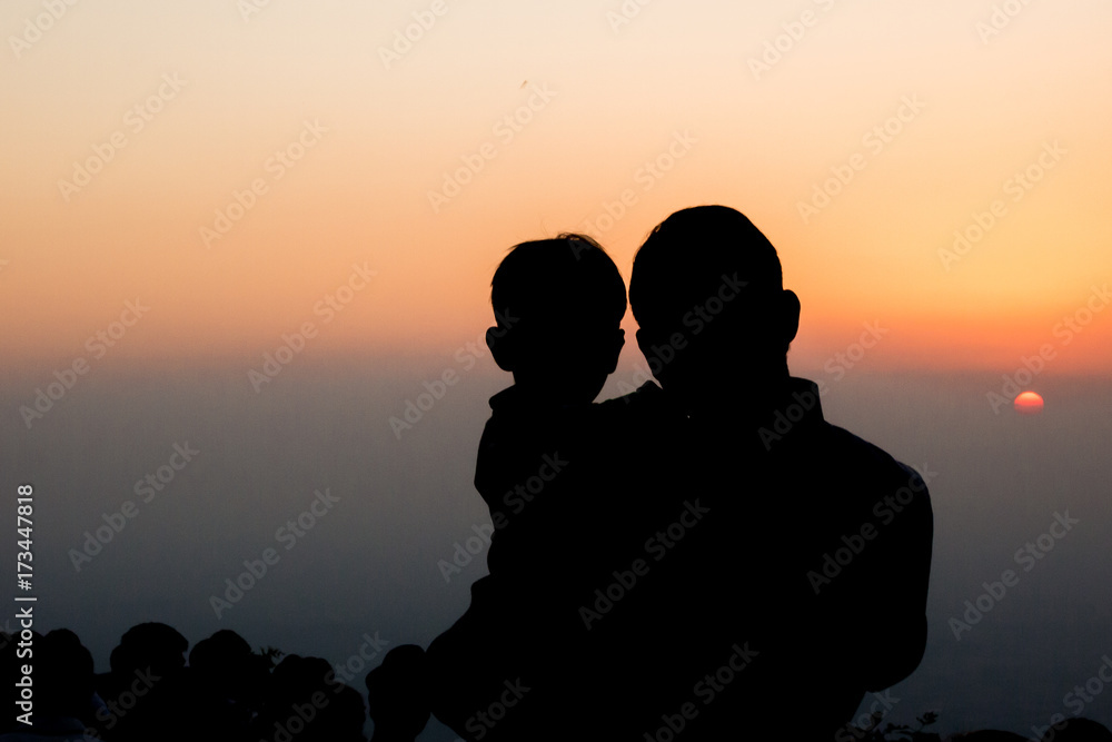 A father and a child watching the sunset