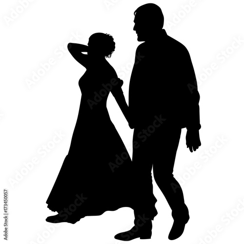 Silhouette of a young guy and a girl in a long dress holding hands