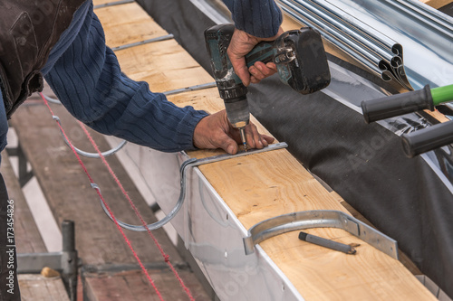 Close-up of a newly installed gutter on a roof. Craftsmanship in tranditional construction.