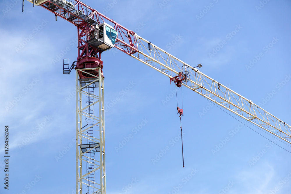 Part of a construction tower crane against the blue sky, copy space Part of a construction tower crane against the blue sky, copy space