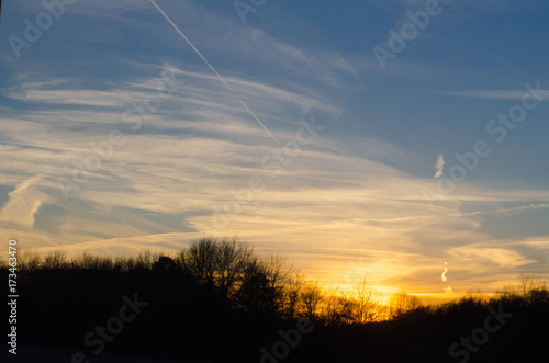 High clouds and contrails punctuate a winter sunset in Alabama, USA