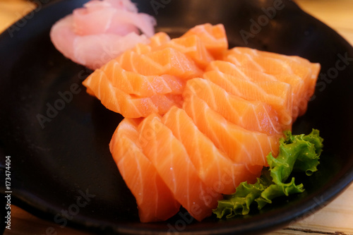 Sashimi salmon,fresh raw set in black plate on wooden table