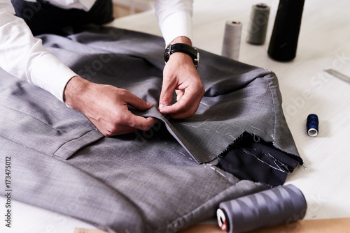 Photos Production process of custom-made male jacket: unrecognizable tailor concentrate