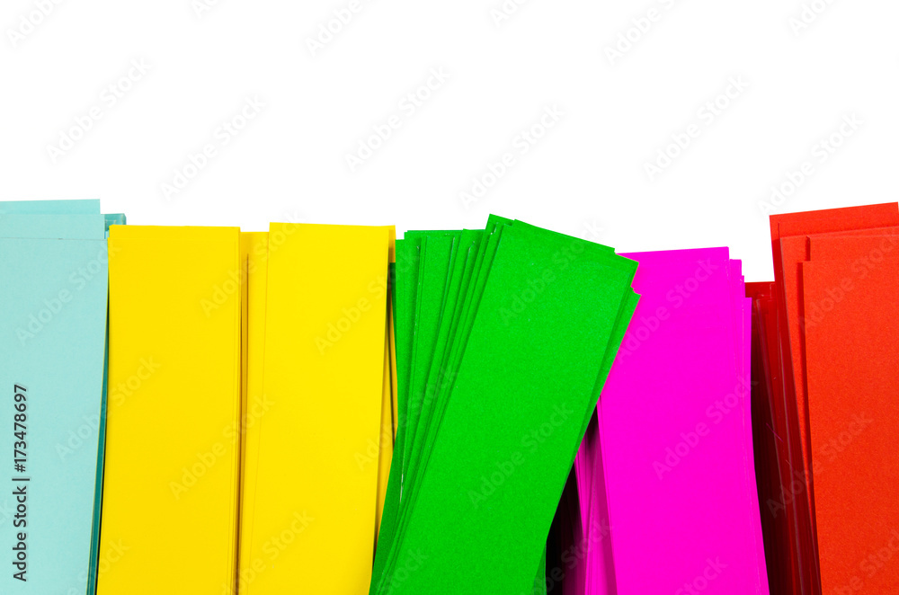 Color paper cut into squares, in blue, yellow, green, red, white on a white background.