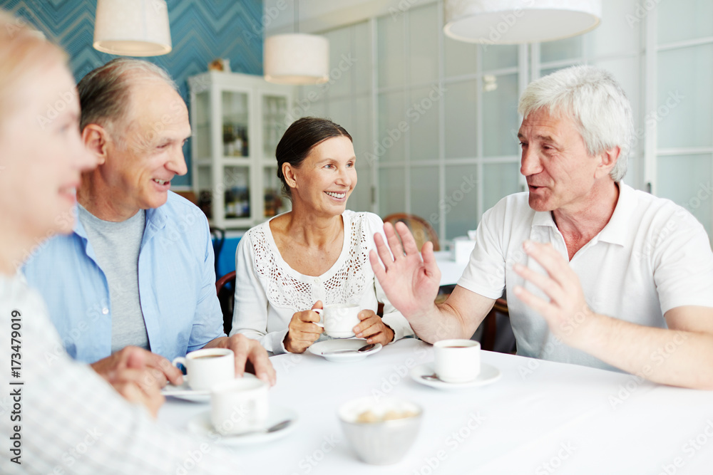 Group of friendly senior people gathered in cafe for talk by cup of coffee Group of friendly senior people gathered in cafe for talk by cup of coffee