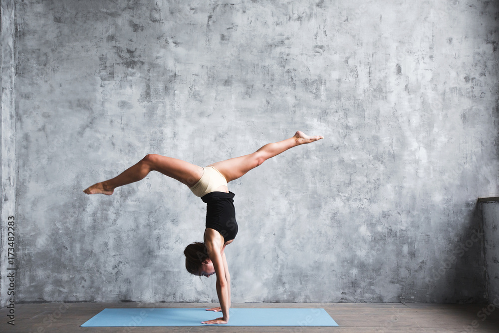 Young attractive yogi woman practicing yoga concept, standing in Adho Mukha Vrksasana exercise. Young attractive yogi woman practicing yoga concept, standing in Adho Mukha Vrksasana exercise.