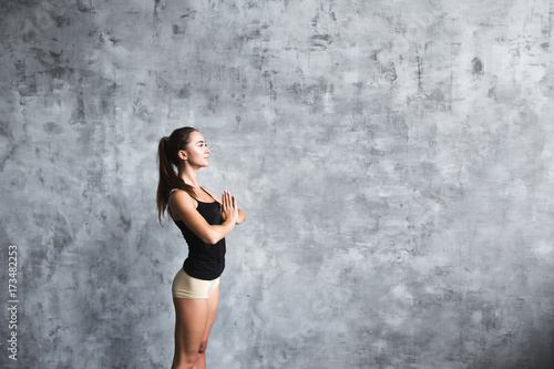 Beautiful smiling young woman workout indoors, doing yoga exercise. © BestForYou