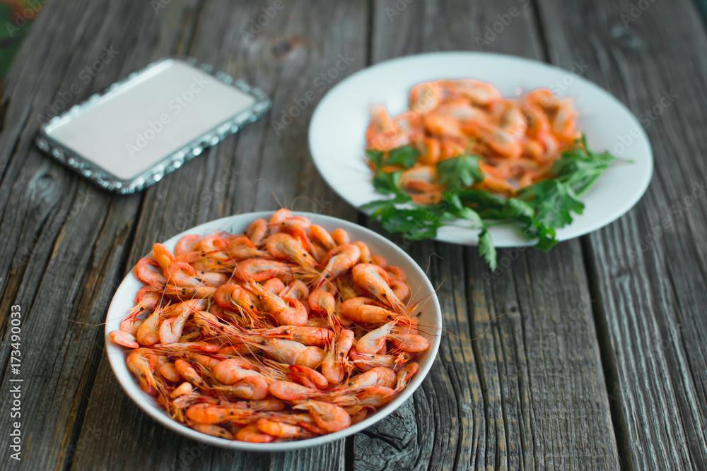 on a wooden background, white plate with shrimps on a wooden background, white plate with shrimps