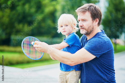 Little boy playing badminton with dad on the playground © Ekaterina Pokrovsky