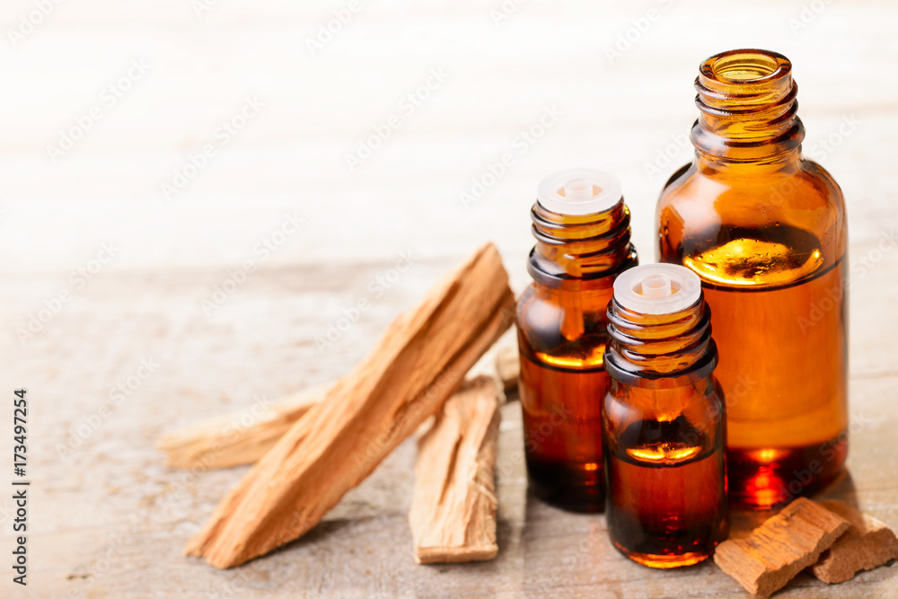 Sandalwood essential oil and wood block on the table Sandalwood essential oil and wood block on the table