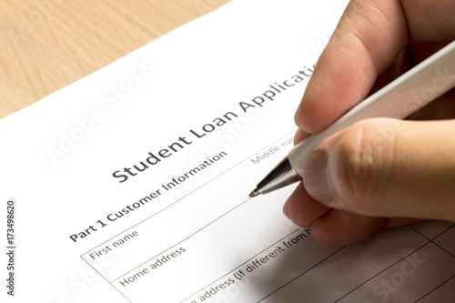 Man wait to fill information in student loan application form on desk background