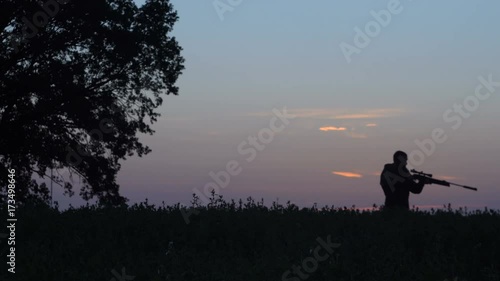 man goes hunting with a gun at sunrise 4k photo