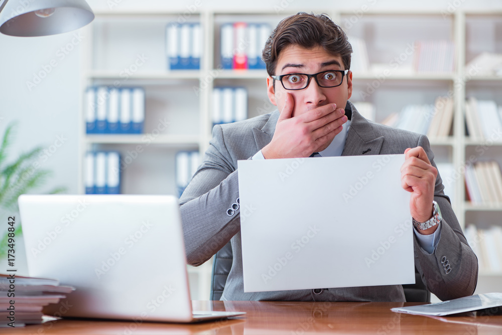 Businessman in office holding a blank message board Businessman in office holding a blank message board