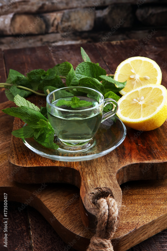Cup of mint tea and leaves of mint on the table Cup of mint tea and leaves of mint on the table