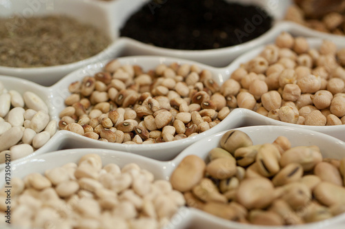 beans, chickpeas and other legumes in plates are set for an example on a show-window
