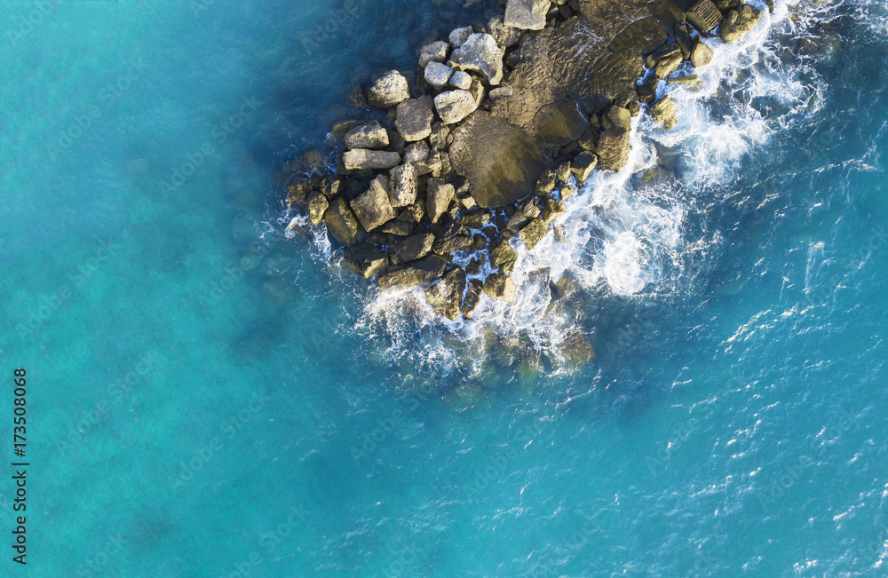 Aerial photo above rock outcrop in crystal clear warm water. 