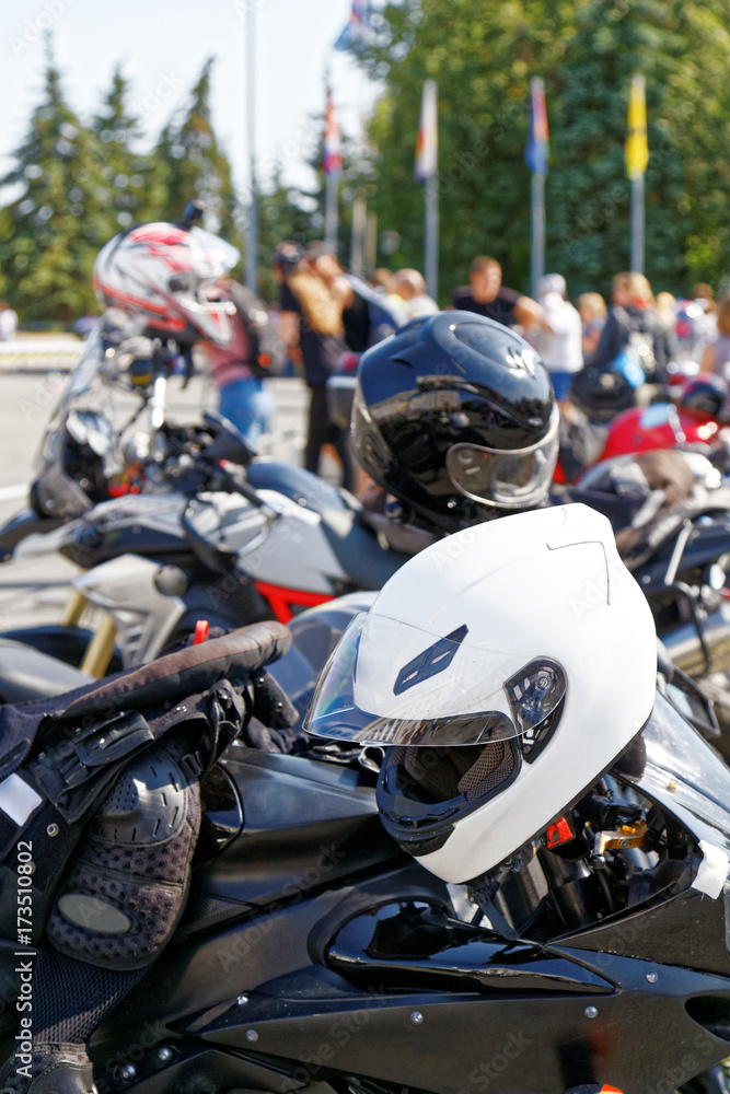 Moto helmets on motorcycles and motorbikes on blurred background Moto helmets on motorcycles and motorbikes on blurred background