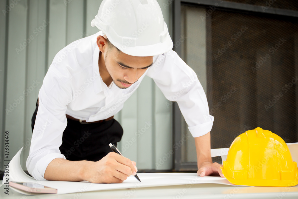 Asian engineer wrinting on blueprint close up. Asian engineer wrinting on blueprint close up.