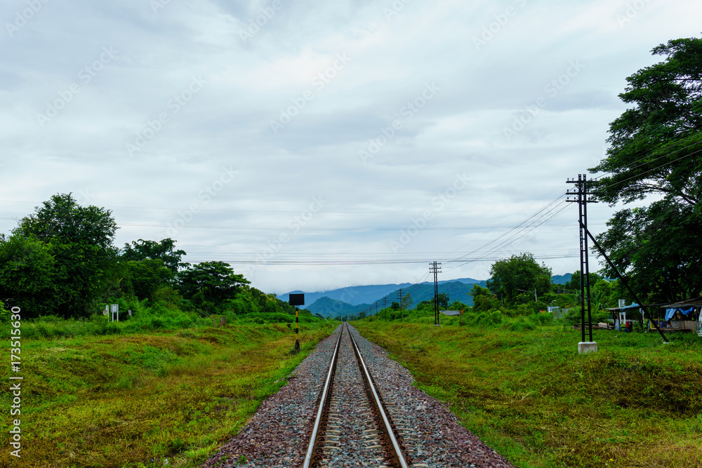 Fototapeta premium landscape view of railway track heading into the valley with cloudy sky