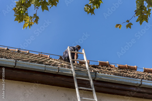 man repairs the roof after the storm