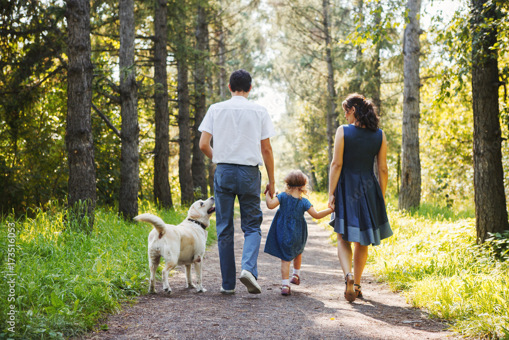 Fototapeta premium Happy family with dog walking in the Park