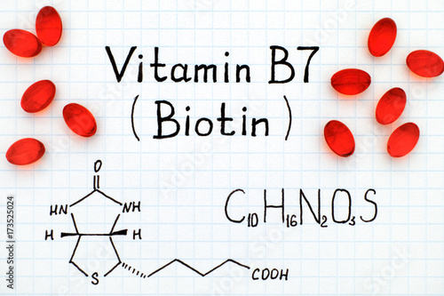 Chemical formula of Vitamin B7 (Biotin) with red pills. photo