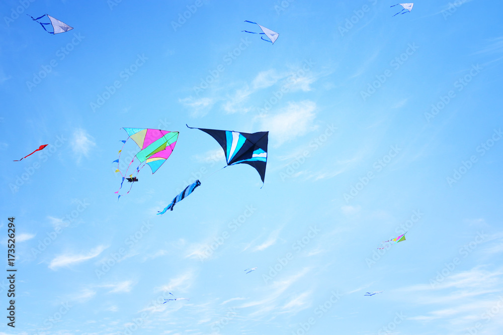 Colorful kite flying in the blue sky through the clouds Stock Photo