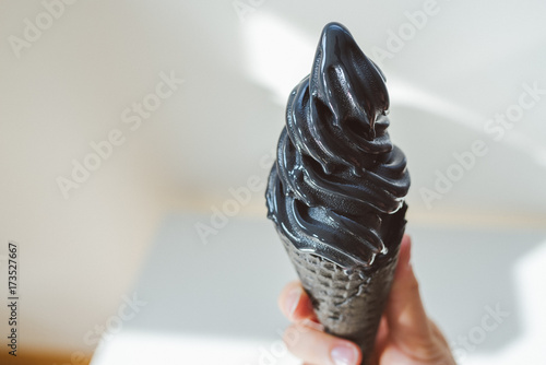 Holding black ice cream, blurred background