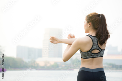 Asian woman warm up to exercise in park in city