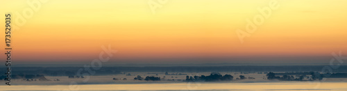 panorama of the big lake in the morning, trees in the fog
