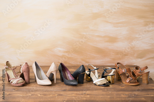 Diferent style woman's high heels on wooden floor