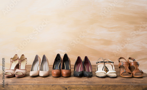Organized woman's shoes on wooden floor