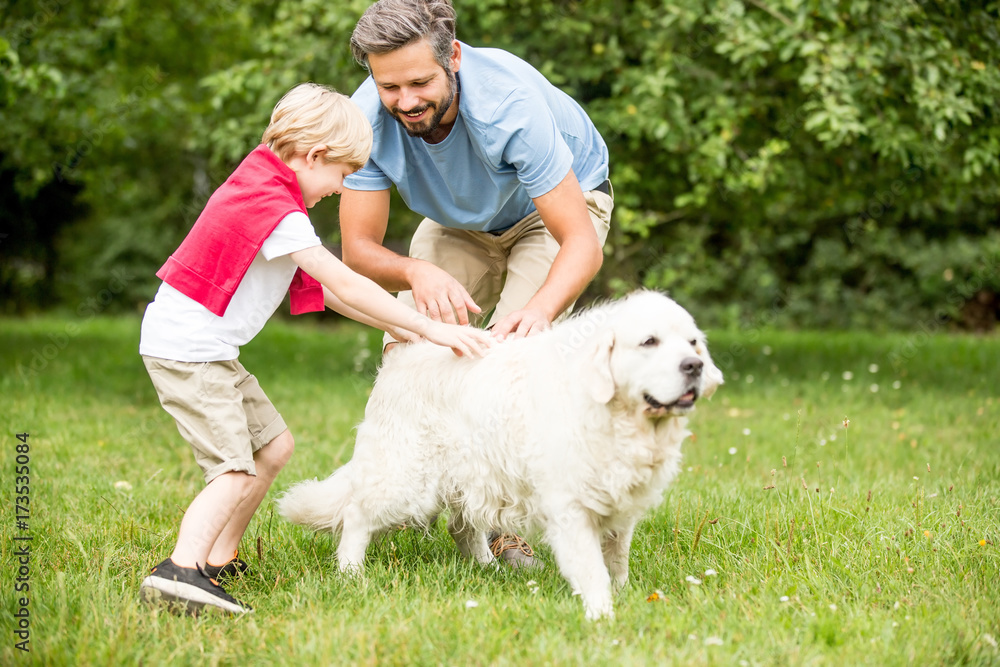 Vater und Sohn spielen mit Hund Vater und Sohn spielen mit Hund