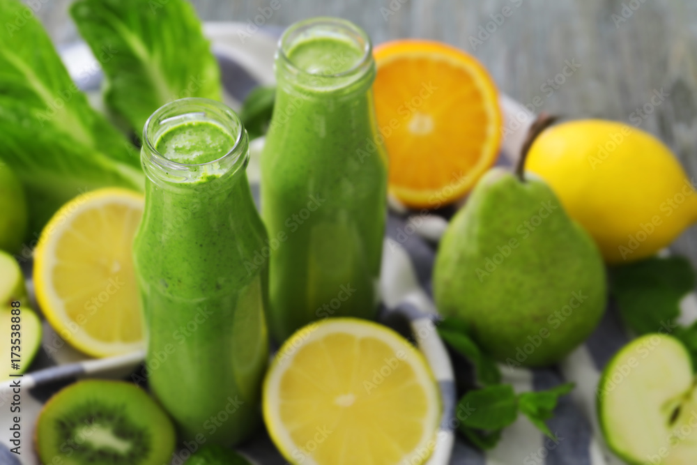 Healthy smoothie with kale in bottles on table Healthy smoothie with kale in bottles on table