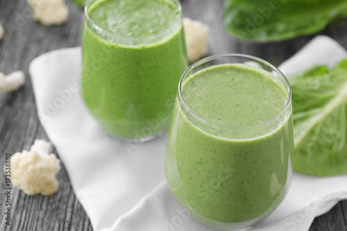 Healthy smoothie with kale in glasses on table