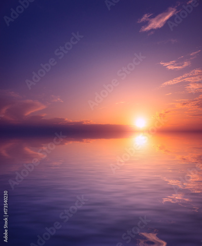 A pink and purple sunset against a background of clear sky and small clouds over the sea waters. © Sviatoslav Khomiakov