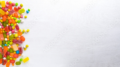 Colored candies  sweets and lollipops. On a white wooden background. Top view. Free space.