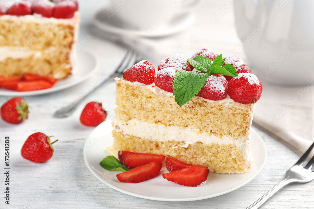 Slice of delicious cake decorated with strawberries and mint on plate Slice of delicious cake decorated with strawberries and mint on plate