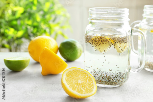 Mason jar with chia seeds, lemon and water on kitchen table