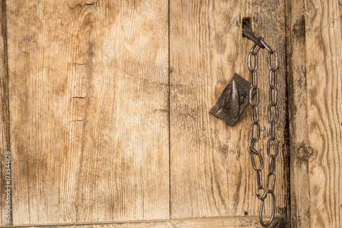 old iron from a wooden door. Closeup vintage door lock of external antique wooden door with the keys o,n weathered on a Country house