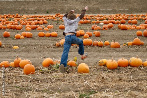 Child Stomping in Pumpkin Patch