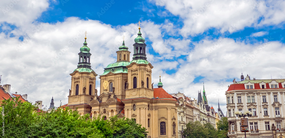 Baroque church of St. Nicholas in Malá Strana quarter in the romantic Prague under blue sky. Panoramic of the old city of the hundred towers on a summer day in the capital of the Czech Republic.