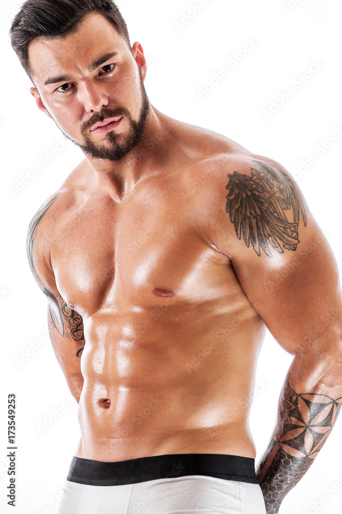 Young man with tattooed torso posing in underwear Young man with tattooed torso posing in underwear