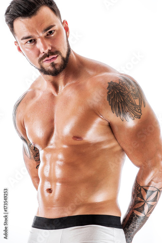 Young man with tattooed torso posing in underwear