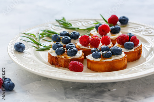 Berry crostini on a white dish.