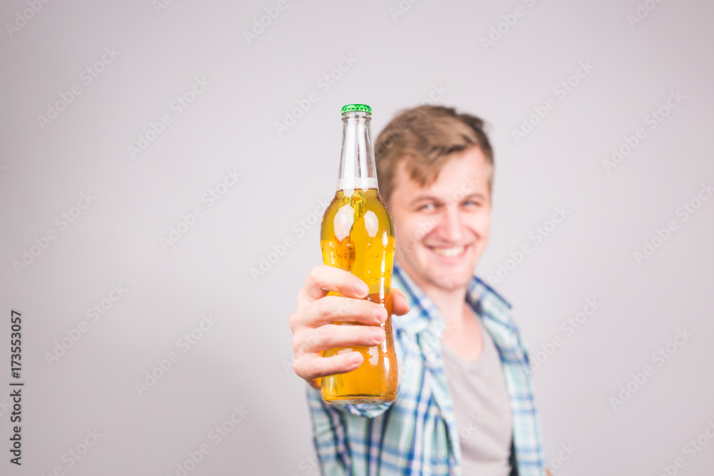 Handsome caucasian man holding a bottle of beer. Background with copy space Handsome caucasian man holding a bottle of beer. Background with copy space