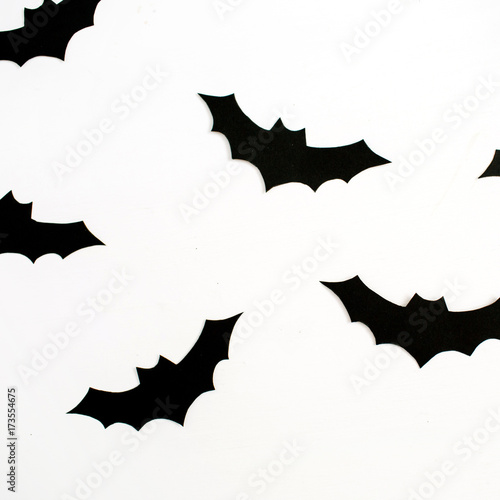 Halloween holiday concept. Handmade black paper bats on white background. Flat lay, top view.