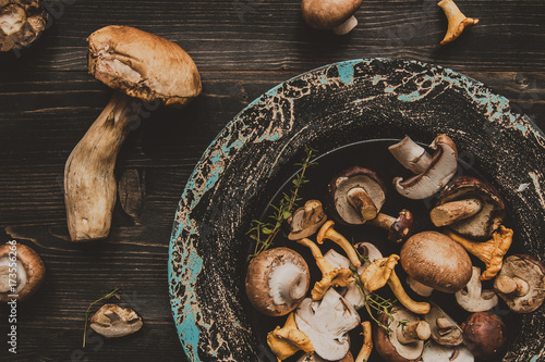 Fresh mixed forest mushrooms on the wooden black table photo