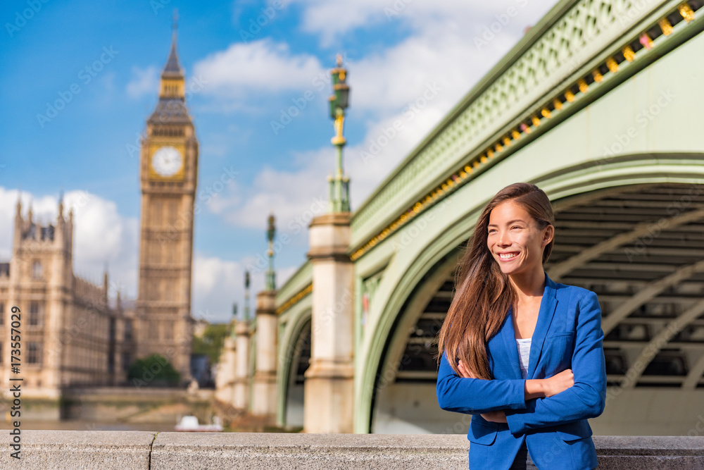London business woman portrait. Urban city lifestyle. Asian businesswoman happy smiling looking towards Big Ben, Westminster, London, UK.